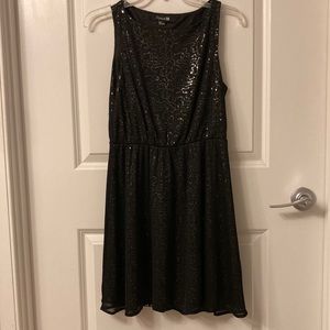 Black sheer dress with sparkle pattern underneath.